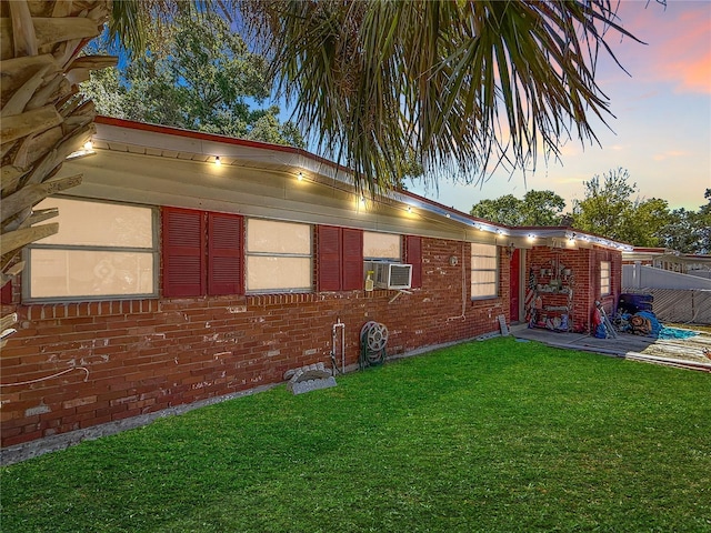 exterior space featuring fence, cooling unit, brick siding, a patio area, and a yard