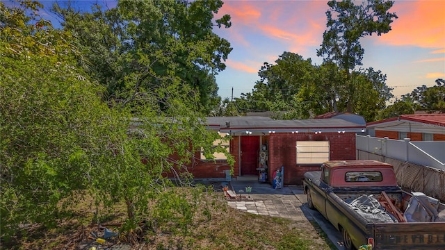 back of property at dusk featuring fence and a patio area
