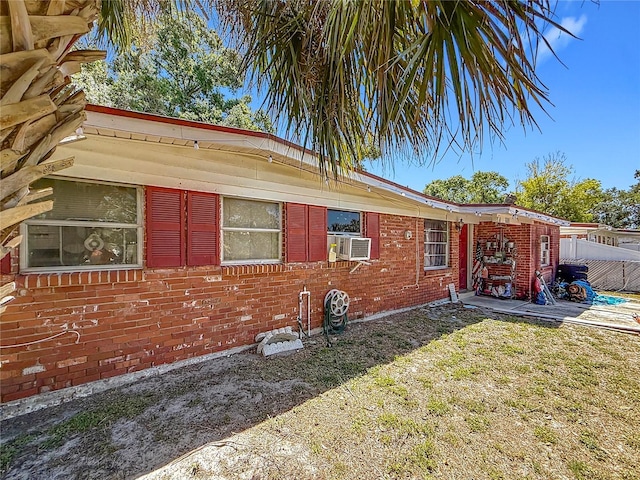 exterior space with fence, cooling unit, a patio area, and brick siding