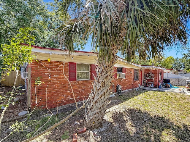 view of side of home featuring brick siding and fence