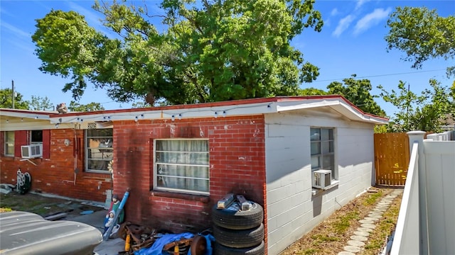 view of property exterior featuring fence and cooling unit