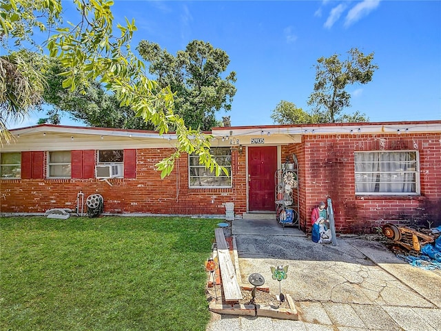 single story home featuring brick siding, cooling unit, and a front lawn