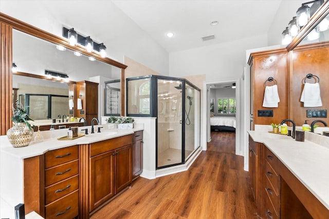 15045 Wind Whisper Dr, Odessa, FL 33556 - ensuite bathroom featuring a shower stall, two vanities, wood finished floors, and recessed lighting