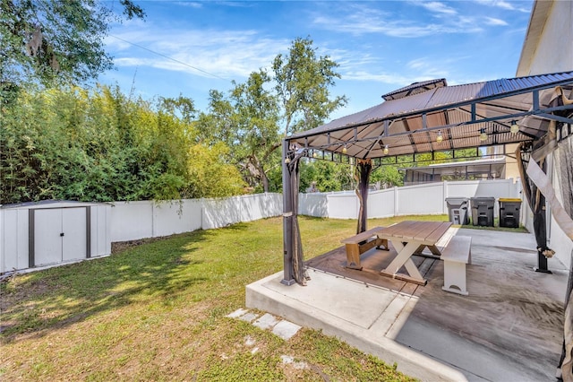view of yard with an outdoor structure, outdoor dining area, a storage shed, a fenced backyard, and a gazebo