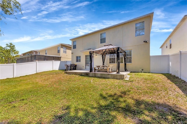 rear view of property with a yard, a fenced backyard, stucco siding, a patio, and a gazebo