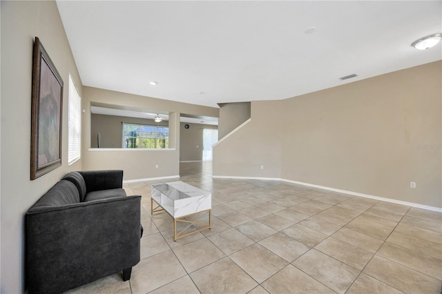 living area featuring light tile patterned floors, baseboards, and visible vents