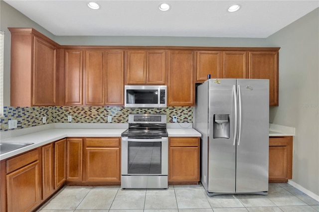 kitchen with light countertops, brown cabinetry, and appliances with stainless steel finishes