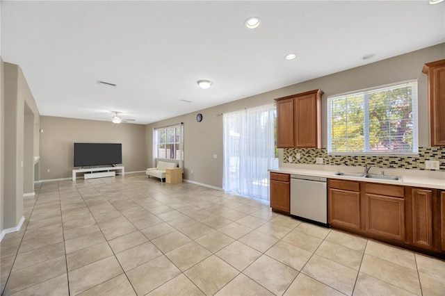 kitchen with brown cabinetry, decorative backsplash, and dishwasher