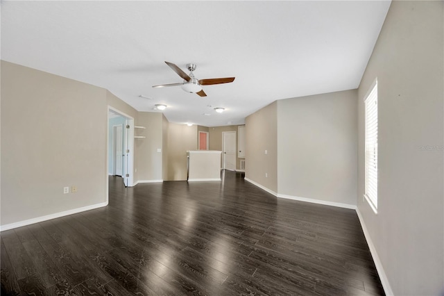 unfurnished living room featuring ceiling fan, baseboards, and dark wood-style flooring