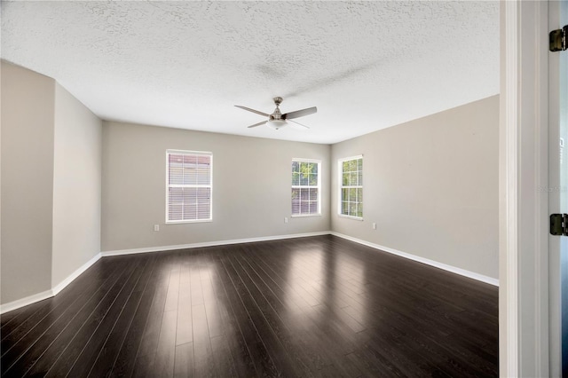 empty room featuring dark wood-style floors, a textured ceiling, baseboards, and a ceiling fan