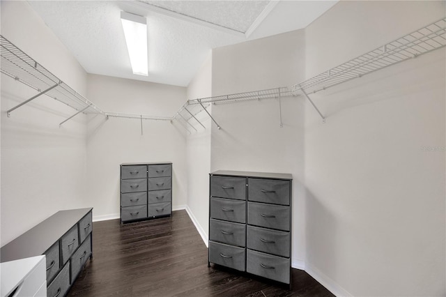 walk in closet with dark wood-type flooring