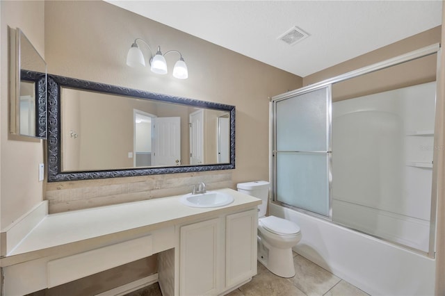 full bath featuring combined bath / shower with glass door, vanity, tile patterned floors, toilet, and visible vents