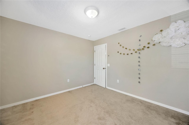 unfurnished room featuring visible vents, baseboards, and light colored carpet