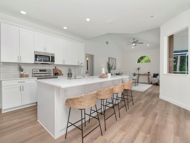 3728 Cypress Meadows Rd, Tampa, FL 33624 - kitchen featuring stainless steel appliances, decorative backsplash, a ceiling fan, a large island with sink, and recessed lighting