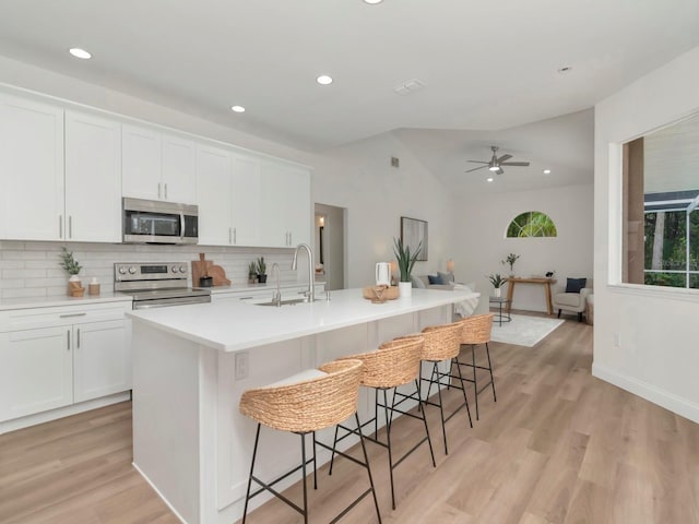 3728 Cypress Meadows Rd, Tampa, FL 33624 - kitchen with stainless steel appliances, decorative backsplash, light wood finished floors, recessed lighting, and ceiling fan