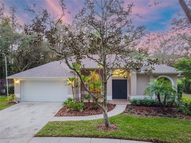 3728 Cypress Meadows Rd, Tampa, FL 33624 - view of front of property with stucco siding, a shingled roof, a garage, concrete driveway, and a front yard