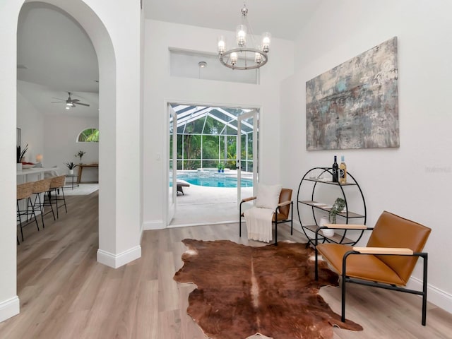 3728 Cypress Meadows Rd, Tampa, FL 33624 - sitting room featuring a sunroom, ceiling fan, wood finished floors, arched walkways, and a towering ceiling