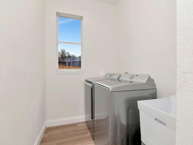 3728 Cypress Meadows Rd, Tampa, FL 33624 - laundry area with washer and clothes dryer, light wood-type flooring, and baseboards