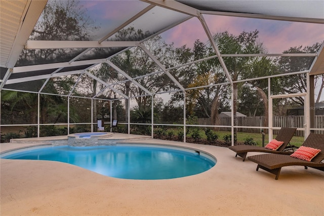 3728 Cypress Meadows Rd, Tampa, FL 33624 - pool at dusk with a fenced backyard, a patio area, a pool with connected hot tub, and glass enclosure
