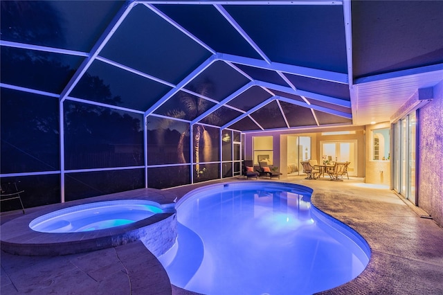 3728 Cypress Meadows Rd, Tampa, FL 33624 - pool at twilight featuring a patio, a pool with connected hot tub, glass enclosure, and outdoor dining space