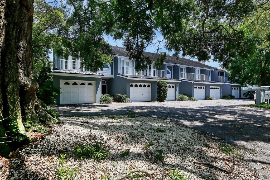 multi unit property with driveway, an attached garage, a balcony, and stucco siding