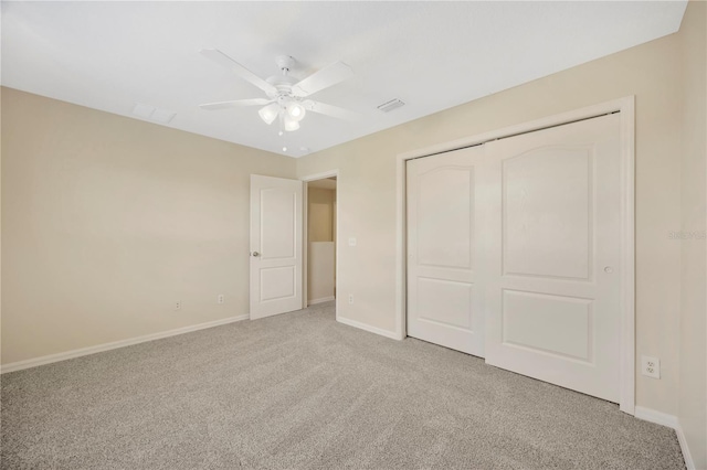 unfurnished bedroom featuring a closet, baseboards, visible vents, ceiling fan, and carpet flooring