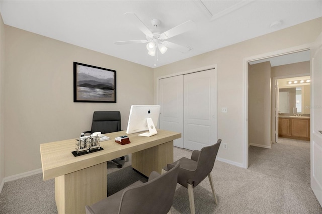 home office with baseboards, a ceiling fan, and light colored carpet