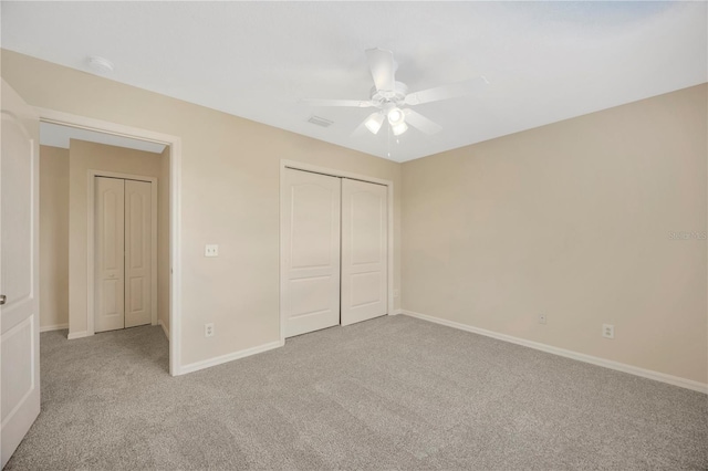 unfurnished bedroom with carpet, a closet, a ceiling fan, visible vents, and baseboards