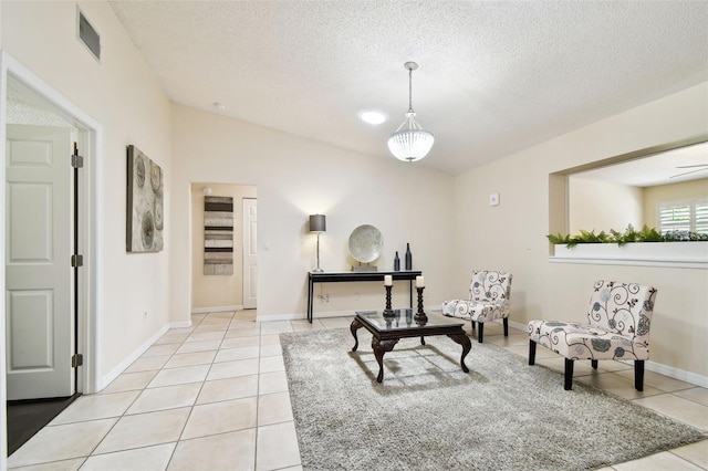 sitting room featuring a textured ceiling, baseboards, light tile patterned flooring, and visible vents
