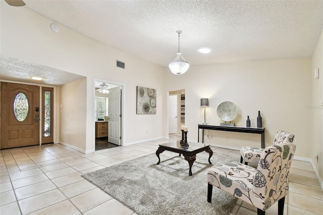 interior space featuring baseboards, a textured ceiling, visible vents, and light tile patterned floors