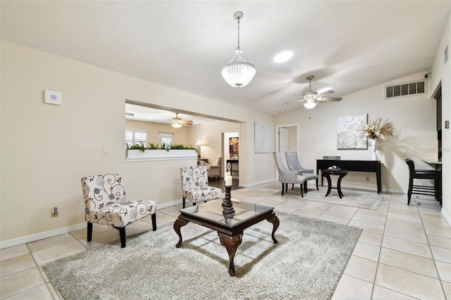 living room with light tile patterned flooring, ceiling fan, visible vents, and lofted ceiling