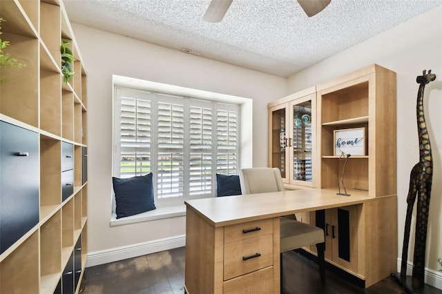 office space featuring baseboards, dark wood-type flooring, a textured ceiling, and ceiling fan