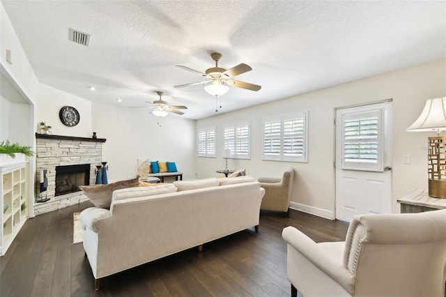 living room with ceiling fan, dark wood-style floors, a textured ceiling, and visible vents
