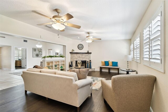 living room with hardwood / wood-style floors, ceiling fan, a healthy amount of sunlight, and a fireplace