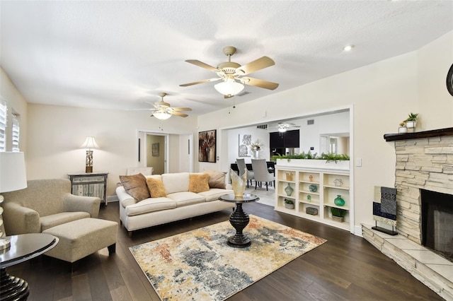 living room featuring baseboards, dark wood-style flooring, ceiling fan, and a fireplace