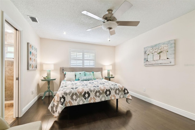 bedroom featuring baseboards, a textured ceiling, and visible vents