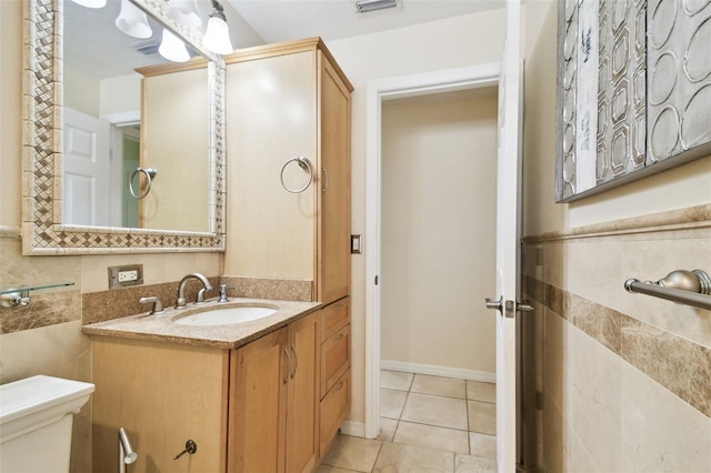half bathroom featuring vanity, tile patterned floors, toilet, and visible vents