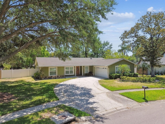 ranch-style home featuring concrete driveway, an attached garage, fence, and a front lawn