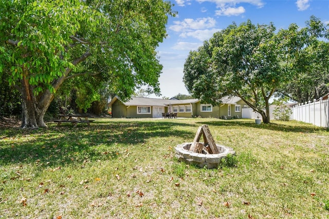 view of yard featuring a fire pit and fence