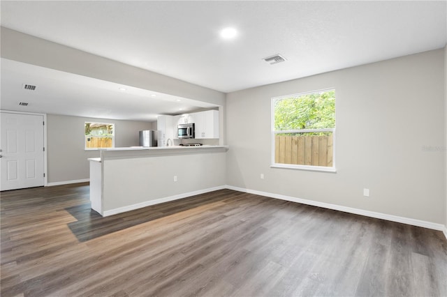 kitchen with dark wood-style flooring, visible vents, white cabinetry, and stainless steel appliances