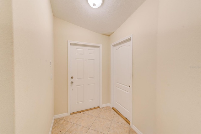 15410 Quail Woods Pl, Ruskin, FL 33573 - doorway to outside with light tile patterned floors, a textured ceiling, and baseboards