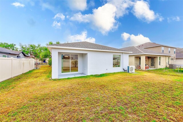 15410 Quail Woods Pl, Ruskin, FL 33573 - rear view of house featuring ac unit, fence, a lawn, and stucco siding