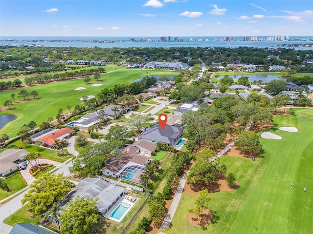 drone / aerial view featuring a water view, view of golf course, and a residential view