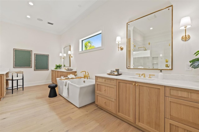 full bathroom with a stall shower, wood finished floors, a sink, and visible vents