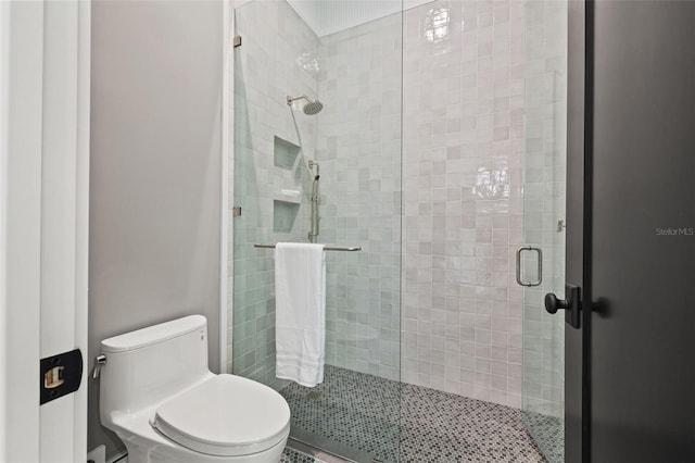 full bath featuring a shower stall and toilet