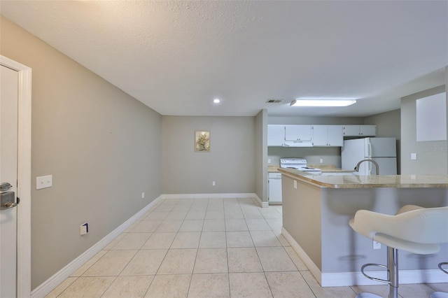9481 Highland Oak Dr Unit 1206, Tampa, FL 33647 - kitchen with white appliances, light countertops, a kitchen bar, ventilation hood, and light tile patterned flooring