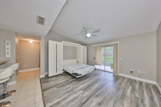 9481 Highland Oak Dr Unit 1206, Tampa, FL 33647 - bedroom with access to outside, vaulted ceiling, light wood finished floors, and ceiling fan