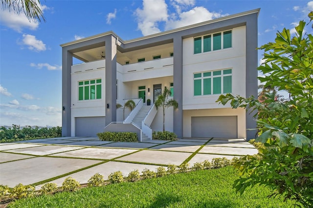 90 Martinique Ave, Tampa, FL 33606 - view of front of home featuring driveway, an attached garage, stairway, a balcony, and stucco siding