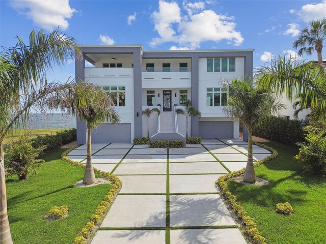 90 Martinique Ave, Tampa, FL 33606 - art deco inspired home featuring a balcony, concrete driveway, an attached garage, a front yard, and stucco siding
