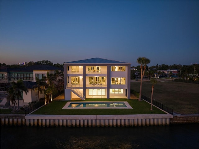 90 Martinique Ave, Tampa, FL 33606 - back of property at dusk with metal roof, a yard, a fenced in pool, and a balcony